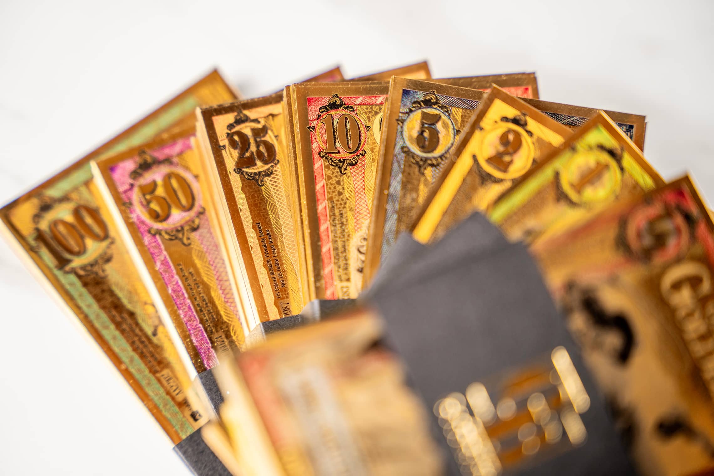 Goldback currency notes fanned out showing different values